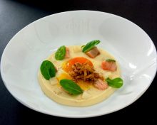 Velours de carottes blanches, jaune d’œuf confit, oignon frit, lardons de saumon frais, brunoise de radis blanc