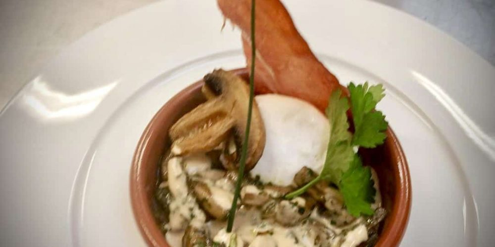 Oeuf poché aux champignons de Paris confits, tuile au jambon Serrano