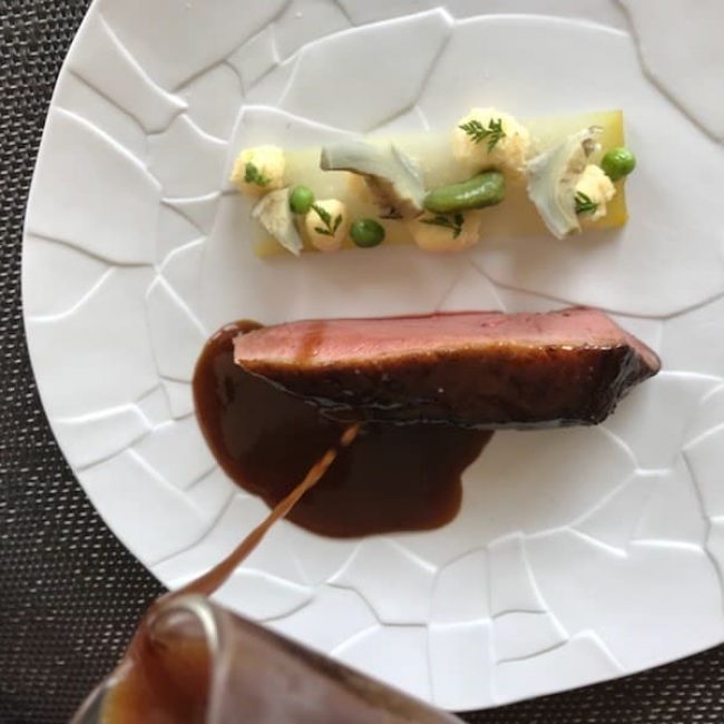 Magret de canard cuit rosé, puis laqué aux bourgeons de sapin, pressé de céleris et légumes du moment